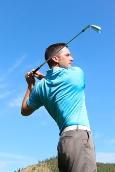 Young golfer hitting a shot with an iron 