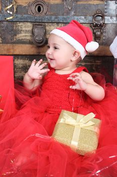 Brunette christmas baby girl wearing a long red tulle dress