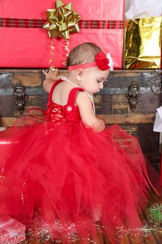 Brunette christmas baby girl wearing a long red tulle dress