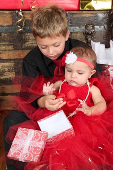 Young boy with his baby sister opening a gift box