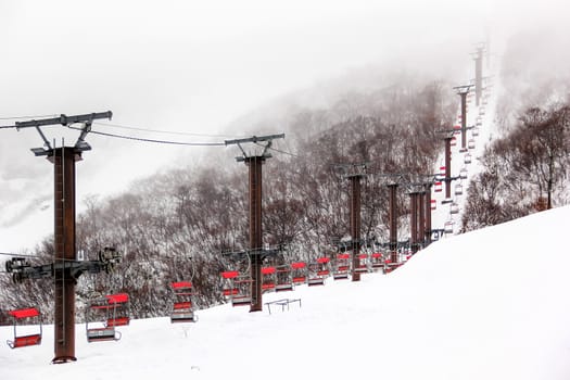 Ski chair lift with skiers on mountain