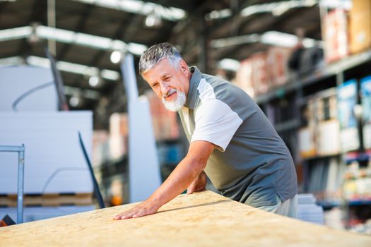 Man choosing and buying construction wood in a  DIY store for his DIY home re-modeling project