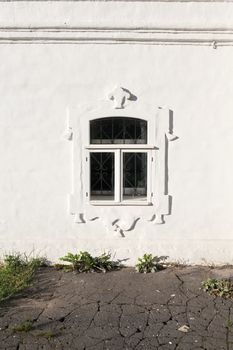 monastic cell window on old white wall of the monastery