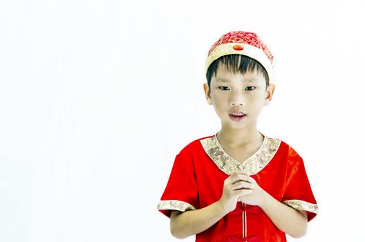 China boy in traditional Chinese red Tang suit greeting