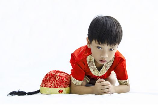 China boy in traditional Chinese red Tang suit greeting