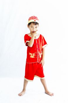 China boy in traditional Chinese red Tang suit greeting