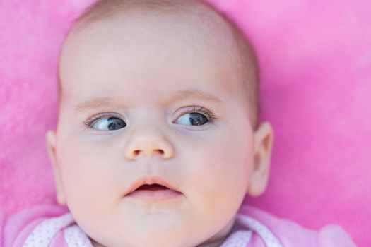 close up of adorable baby face in pink back ground