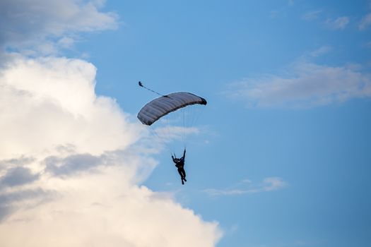 silhouette of unidentified skydiver parachutist on blue sky on sunset