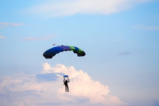 silhouette of unidentified skydiver parachutist on blue sky on sunset
