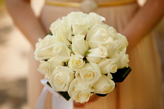 Bride holding wedding flower bouquet of yellow roses