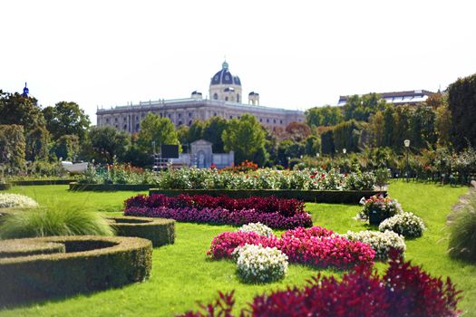 Vienna city hall tower seen behind green park and flowers