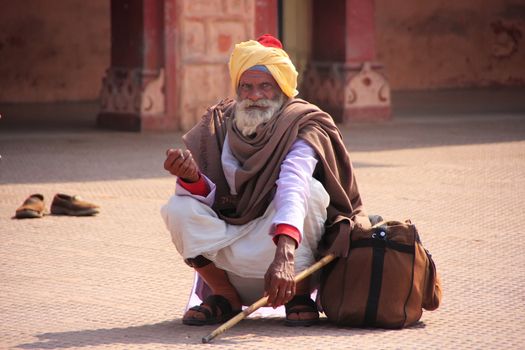 Indian man sitting at train station, Sawai Madhopur, Rajasthan, India