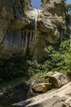 Man under big waterfall high in to the Navarra's mountain