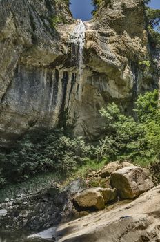 Man under big waterfall high in to the Navarra's mountain