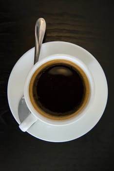 Black coffee in white cup on the wooden table.