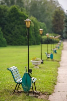 park bench with trashcans in row, selective focus on first