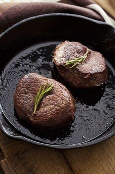 Beef steak in pan on wooden background