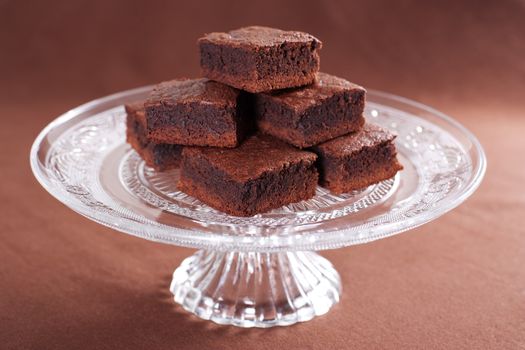 Chocolate brownies on the glass cake stand 