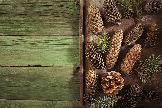 Christmas fir cones on vintage green wooden background