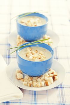 Vegetable tasty cream soup in blue bowls