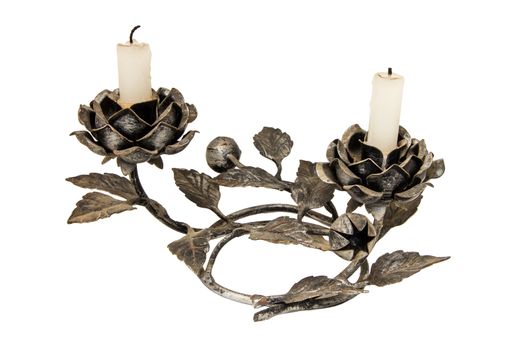 A cast iron candle holder with rose elements