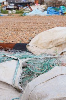 Large bags of nylon commercial fishing nets stored on a working beach in Hastings, England