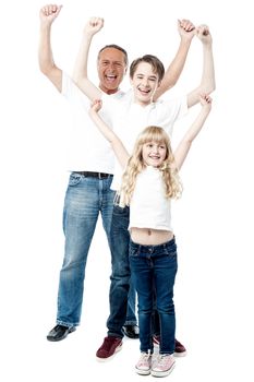Happy family celebrating with arms up