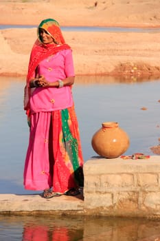 Local woman getting water from reservoir, Khichan village, Rajasthan, India