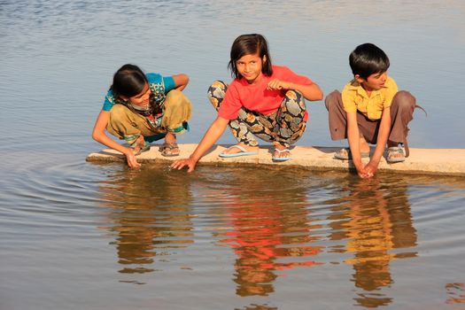 Local kids drinking from water reservoir, Khichan village, Rajasthan, India