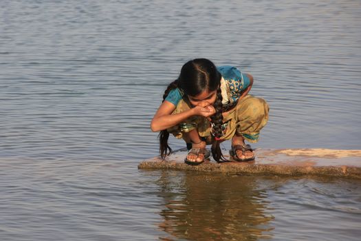 Local girl drinking from water reservoir, Khichan village, Rajasthan, India