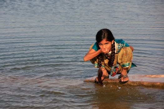 Local girl drinking from water reservoir, Khichan village, Rajasthan, India