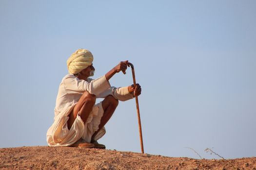 Local man sitting on a hill, Khichan village, Rajasthan, India