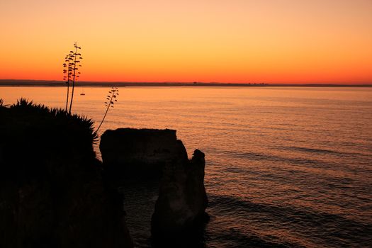 Silhouetted cliffs at sunrise, Ponta de Piedade, Lagos, Algarve region, Portugal
