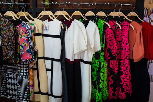 Colorful blouse hanging on clothesline in a shop.