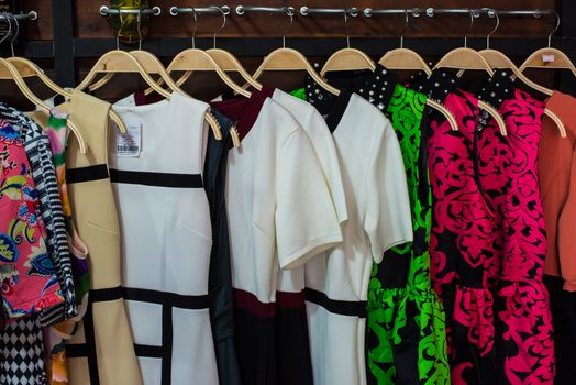 Colorful blouse hanging on clothesline in a shop.