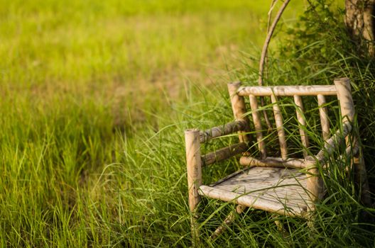 Bamboo wooden chairs on grass field in countryside Thailand