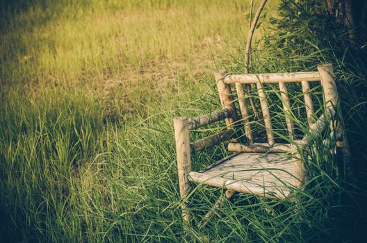 Bamboo wooden chairs on grass field in countryside Thailand vintage