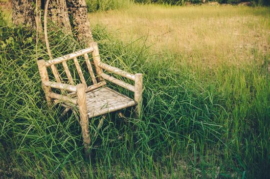 Bamboo wooden chairs on grass field in countryside Thailand vintage