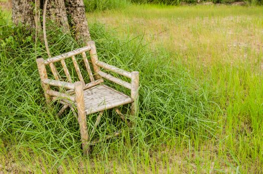 Bamboo wooden chairs on grass field in countryside Thailand