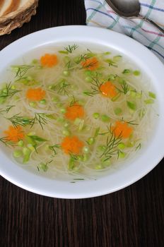 Chicken vermicelli soup with green peas and carrots