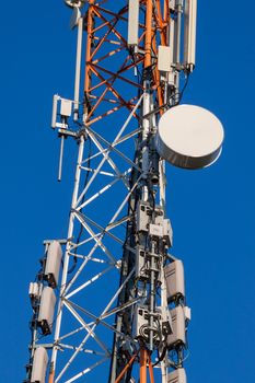 Communications tower with antennas against blue sky