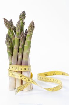 Raw asparagus and measuring type isolated on a white background
