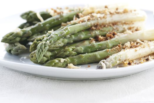 Asparagus gratin on white plate on white background