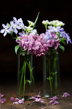 Beautiful spring flowers in a vase on wooden background