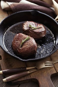 Beef steak in pan on wooden background