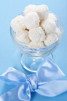 Homemade coconut candies in a bowl with a bow