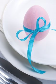 Easter table setting with plates, napkin, silverware and easter egg