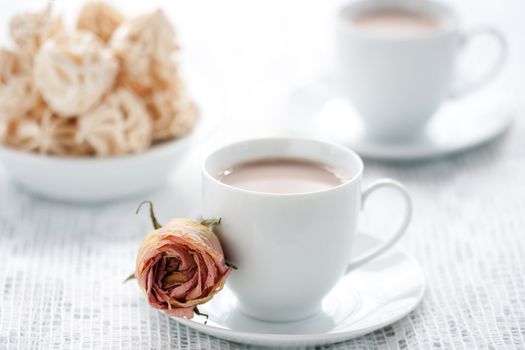 Meringues and two cups of chocolate drink, shallow dof.