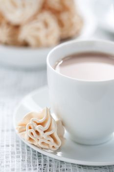 Meringues and cup of chocolate drink, shallow dof.