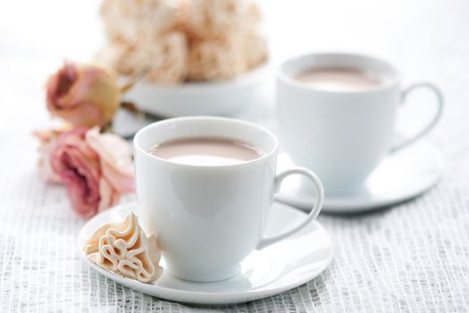 Meringues and cup of chocolate drink, shallow dof.